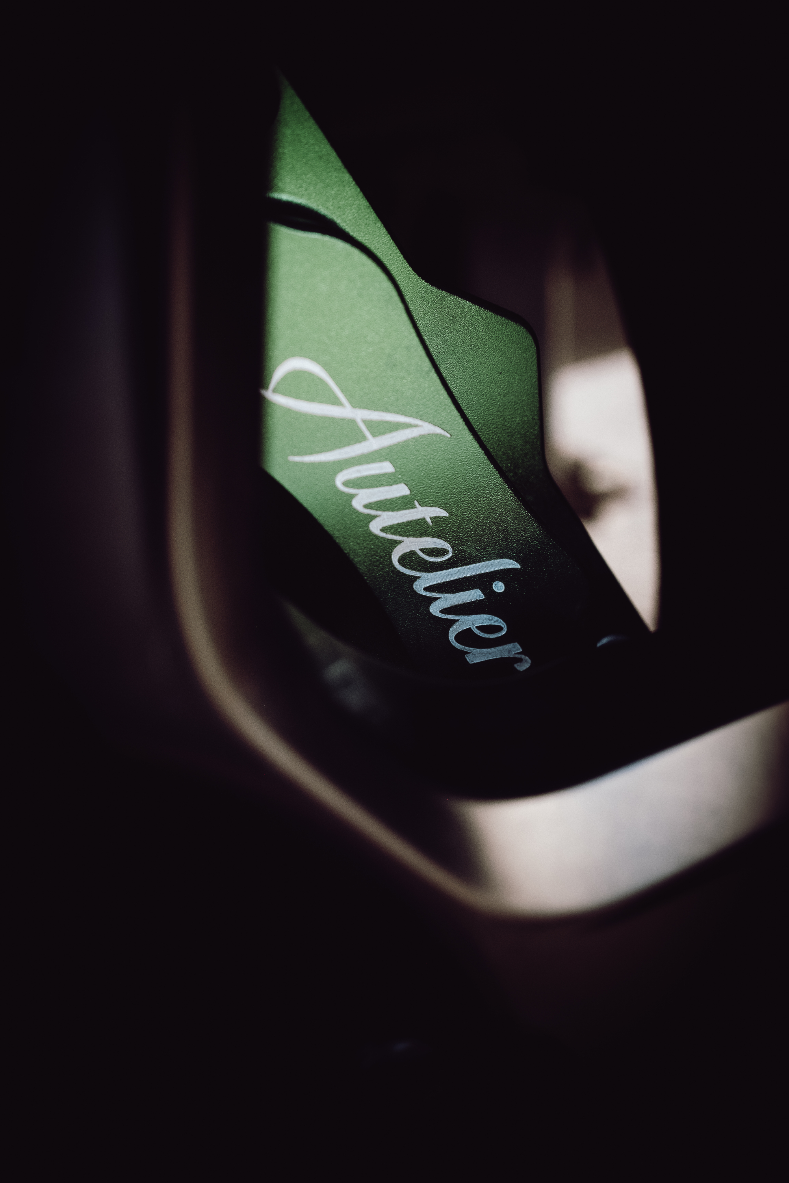 Autelier lettering across the wheelarch of a dark heritage-green Defender