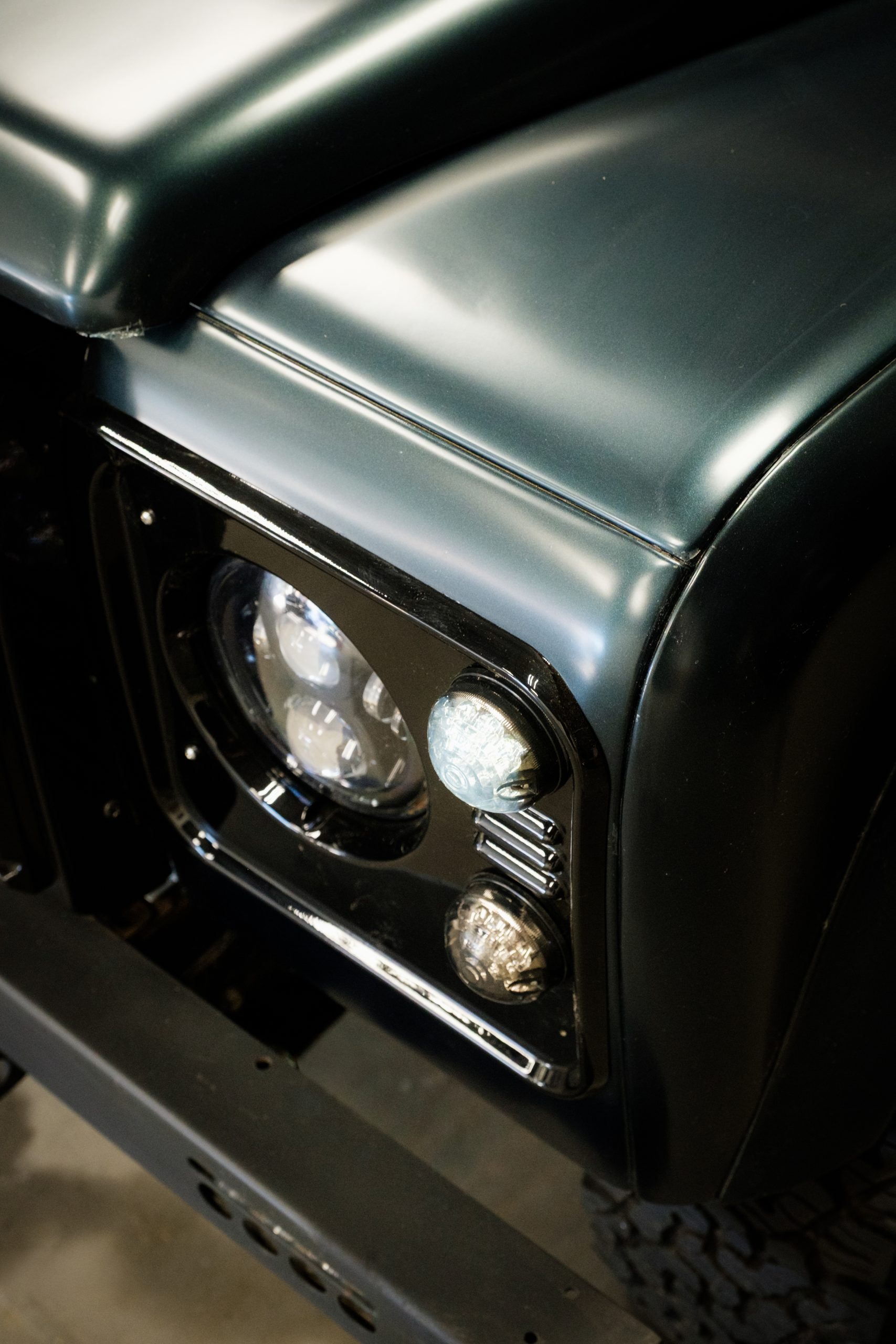 Bespoke Land Rover Defender front wing and headlight in dark heritage green