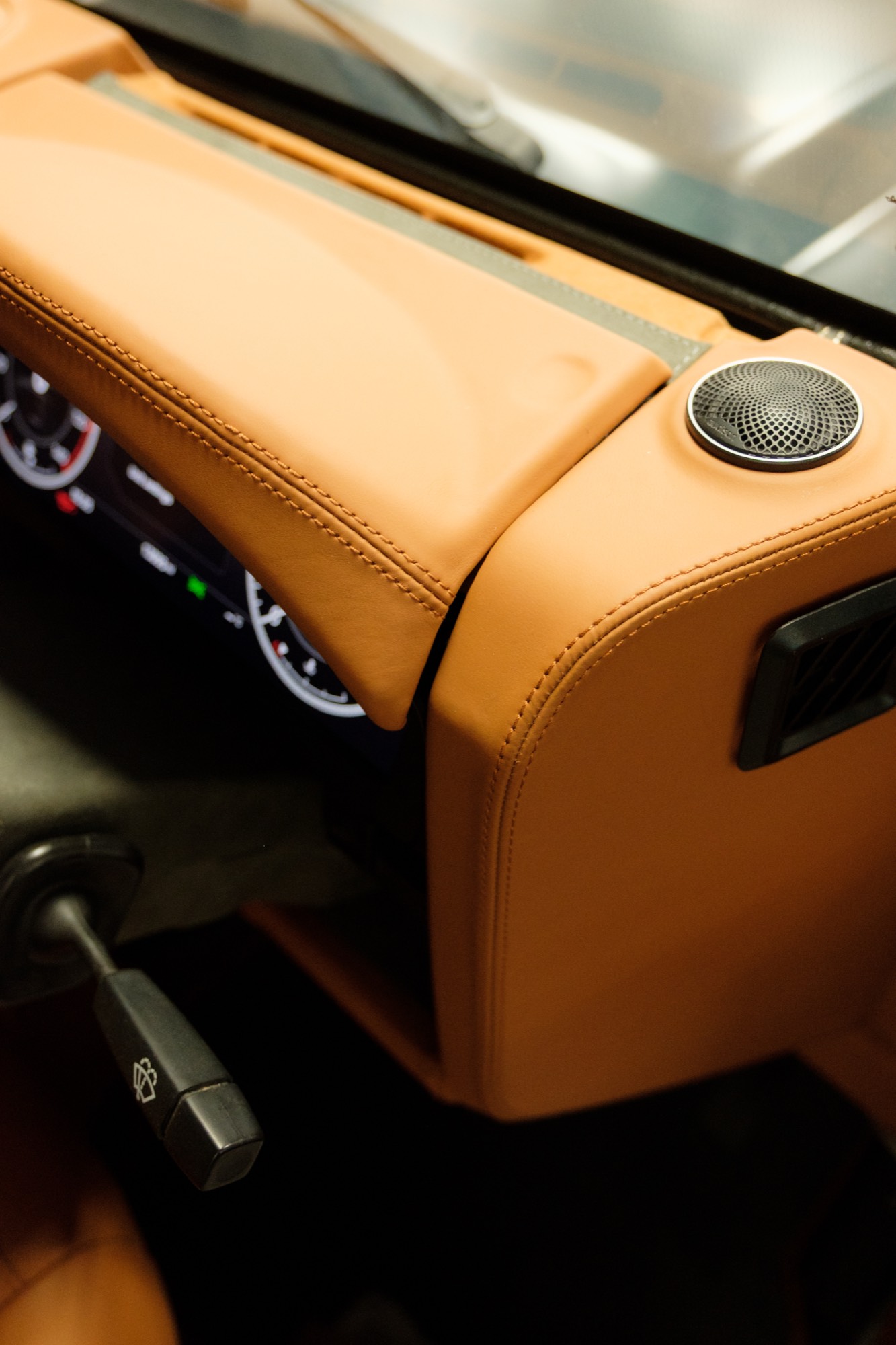 Tan leather dashboard with speaker grille and air vent