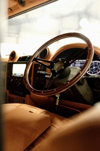 Wood-rimmed steering wheel above the tan leather cabin