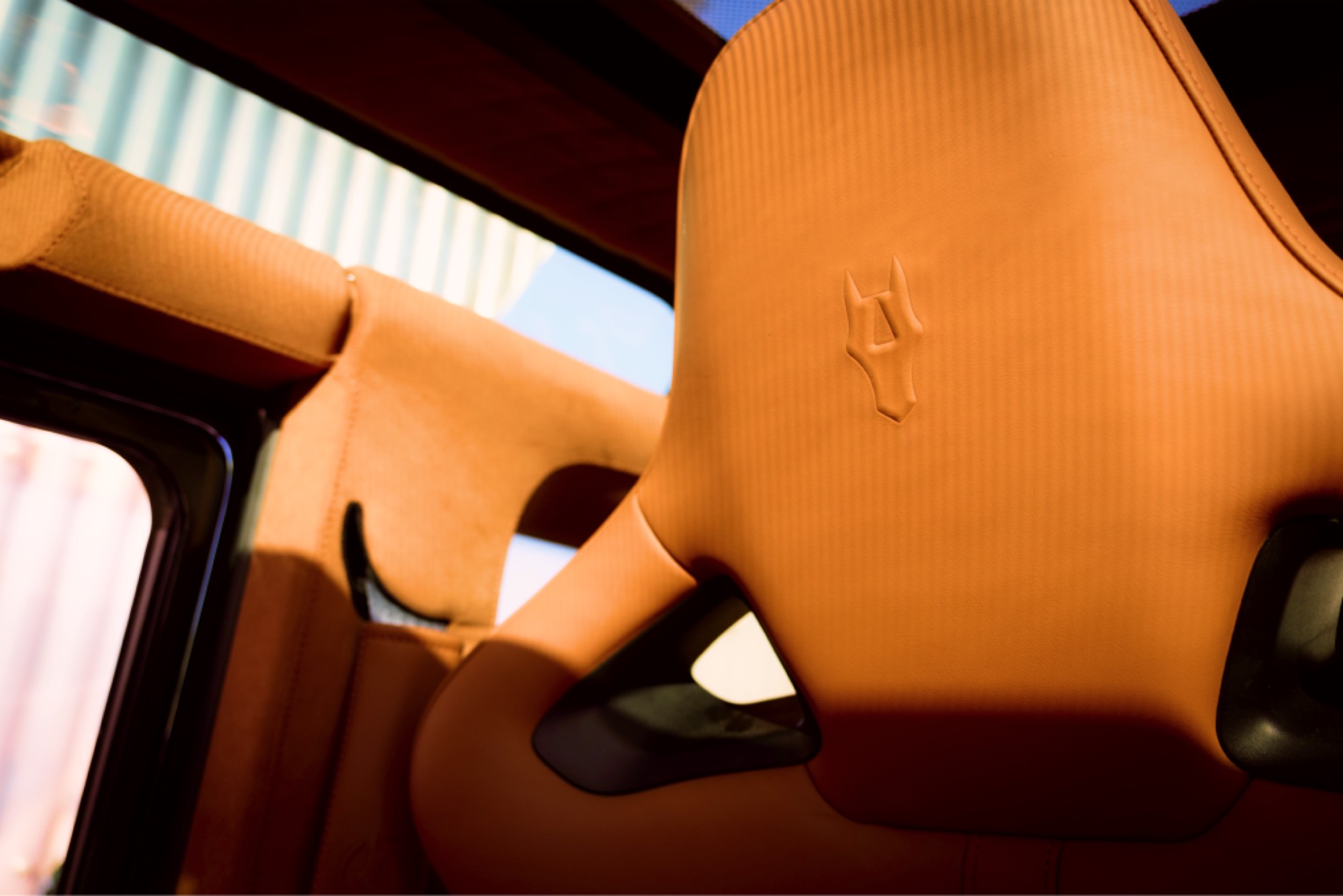 Embossed Autelier crest on a tan leather headrest